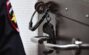 Наручники и шеврон полицейского. Фото Ивана Водопьянова, Коммерсантъ