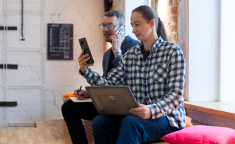 Пара со смартфонами и ноутбуком. Фото предоставлено ПАО «МегаФон»