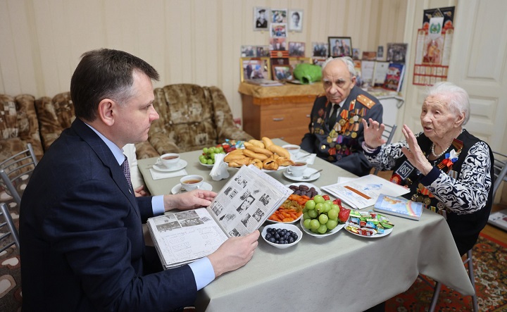 Юрий Слюсарь беседует с семьёй ветеранов. Фото donland.ru
